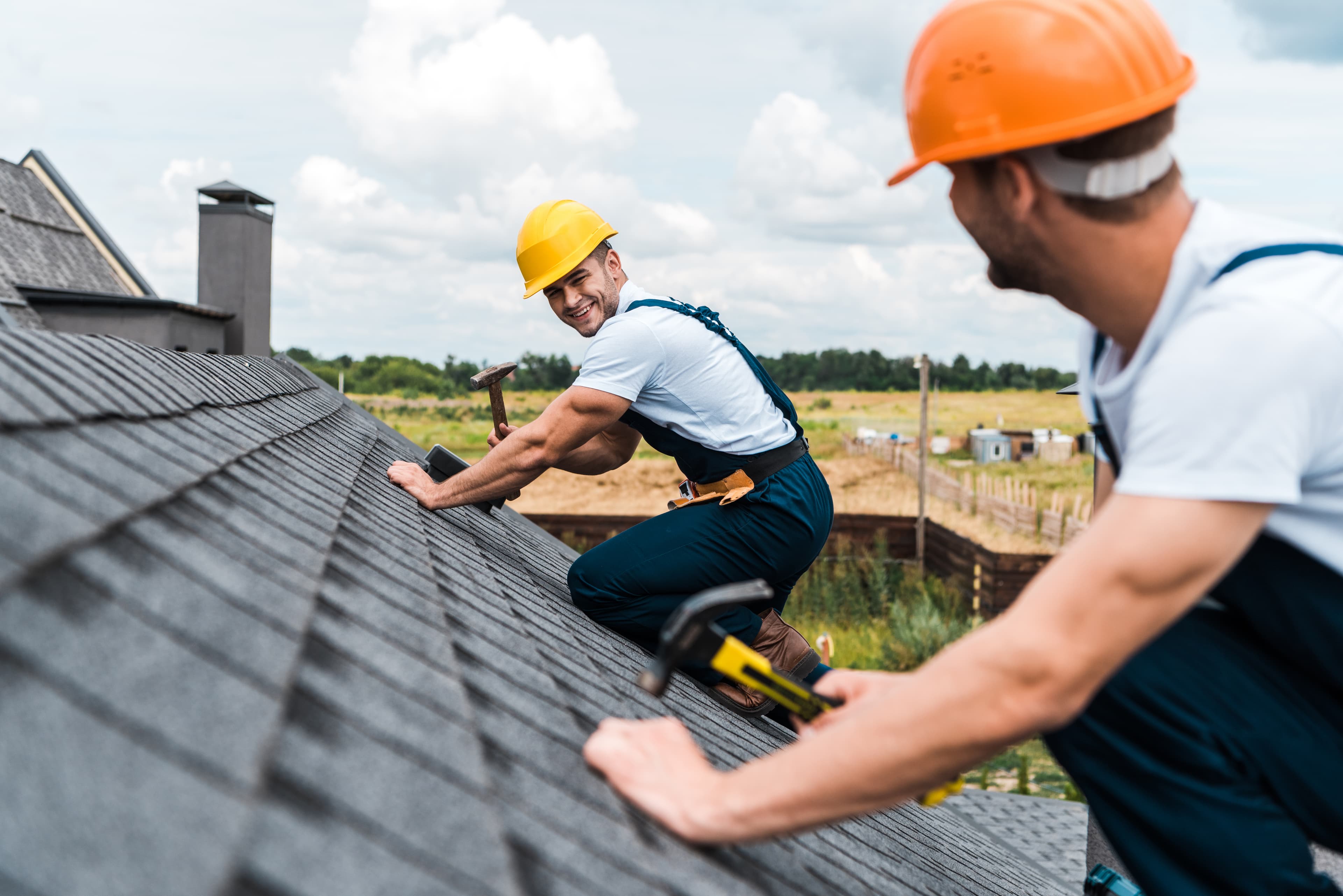 Jansen Dakdekkers vakman glimlachend aan het werk op het dak